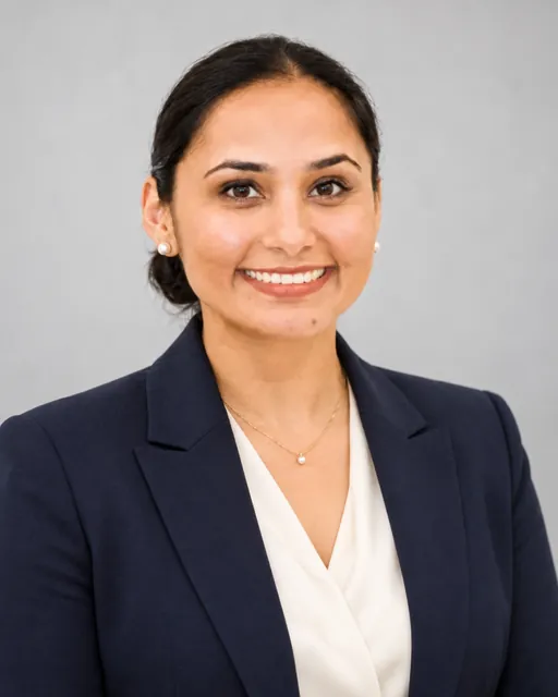 Raj Kiran Kaur in a navy blazer, studio portrait
